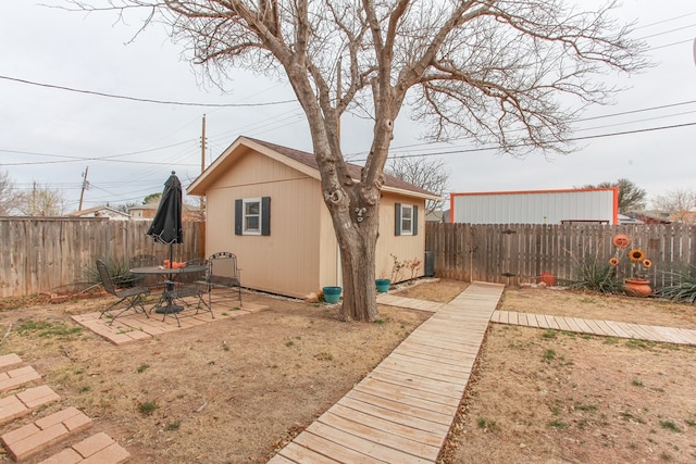 exterior space with a patio, an outdoor structure, central AC unit, and a fenced backyard