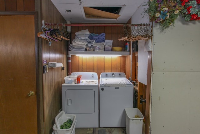 washroom with wooden walls, washing machine and dryer, and laundry area