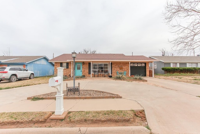 ranch-style house featuring brick siding, curved driveway, and an attached garage