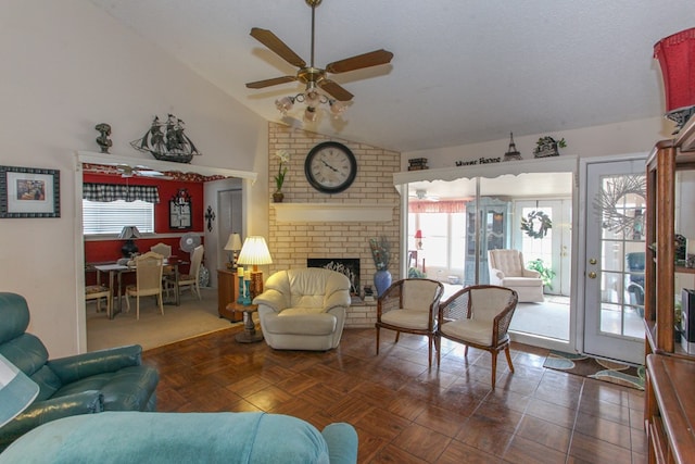 living room with a textured ceiling, high vaulted ceiling, a fireplace, and ceiling fan