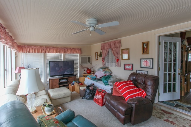 carpeted living area with an AC wall unit and a ceiling fan