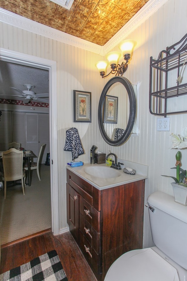 bathroom with an ornate ceiling, toilet, wood finished floors, and vanity