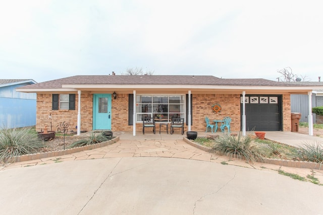 single story home featuring an attached garage, brick siding, driveway, and a shingled roof