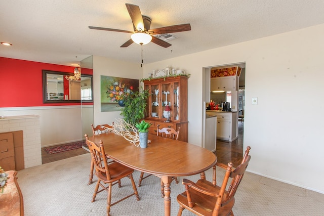 dining area featuring a ceiling fan, baseboards, visible vents, a textured ceiling, and carpet flooring