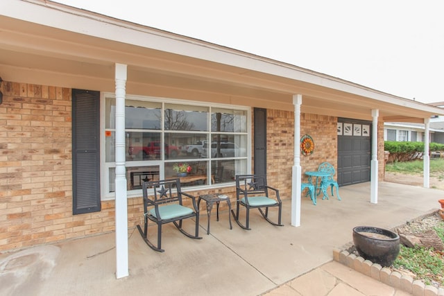 view of patio / terrace with a porch and an attached garage