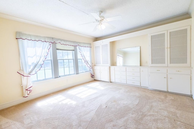 1001 W Walnut St, Coleman, TX 76834 - spare room with light carpet, a ceiling fan, a textured ceiling, and crown molding