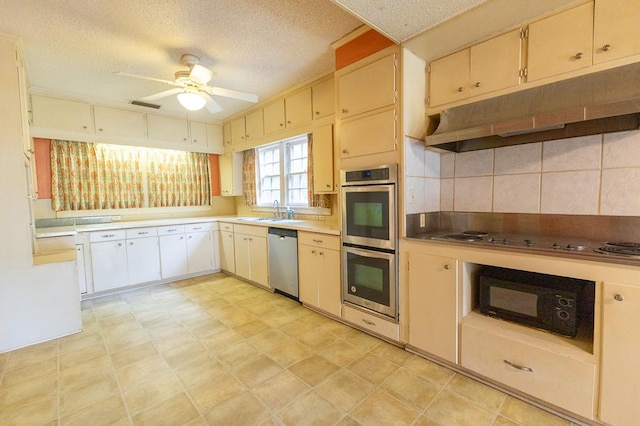 1001 W Walnut St, Coleman, TX 76834 - kitchen with appliances with stainless steel finishes, under cabinet range hood, ceiling fan, decorative backsplash, and a textured ceiling