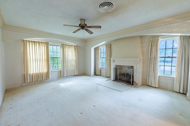 1001 W Walnut St, Coleman, TX 76834 - unfurnished living room with plenty of natural light, a ceiling fan, a textured ceiling, a fireplace, and carpet