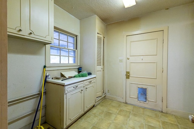 1001 W Walnut St, Coleman, TX 76834 - laundry room featuring a textured ceiling and baseboards