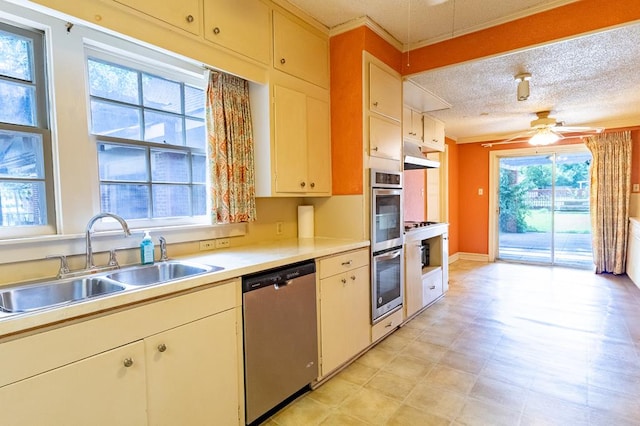 1001 W Walnut St, Coleman, TX 76834 - kitchen featuring stainless steel appliances, ceiling fan, light countertops, a textured ceiling, and crown molding