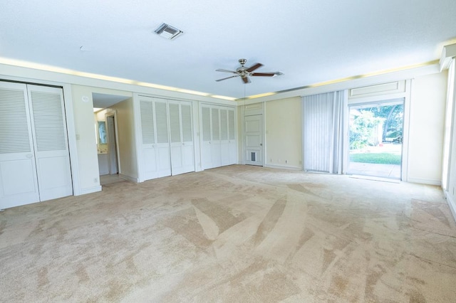 1001 W Walnut St, Coleman, TX 76834 - unfurnished bedroom featuring light carpet, access to exterior, two closets, and a ceiling fan