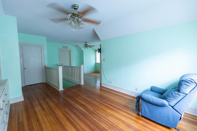 1001 W Walnut St, Coleman, TX 76834 - sitting room featuring a ceiling fan, an upstairs landing, and wood finished floors