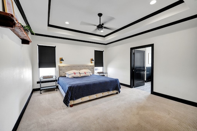 bedroom with light colored carpet, a raised ceiling, crown molding, and baseboards
