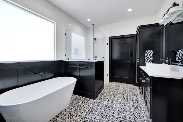 full bath featuring a freestanding tub, vanity, recessed lighting, and a stall shower