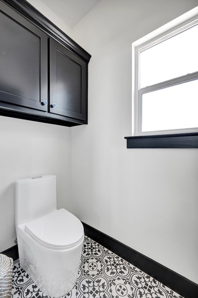 bathroom featuring baseboards and toilet