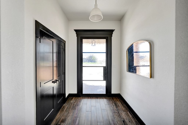 entryway with baseboards and dark wood-type flooring