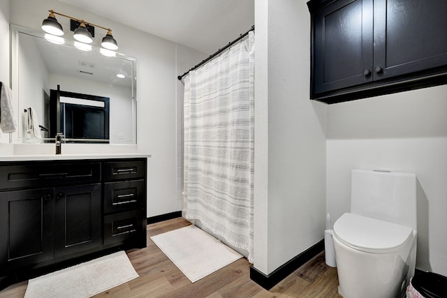 full bathroom with toilet, wood finished floors, vanity, and curtained shower