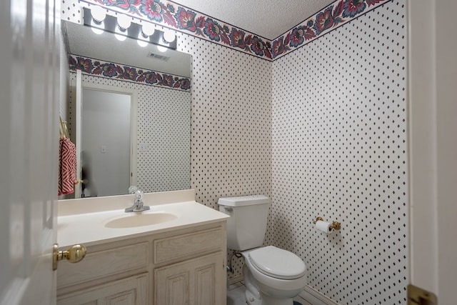 5411 Ridgemont Ct, Midland, TX 79707 - bathroom with wallpapered walls, toilet, a textured ceiling, and vanity