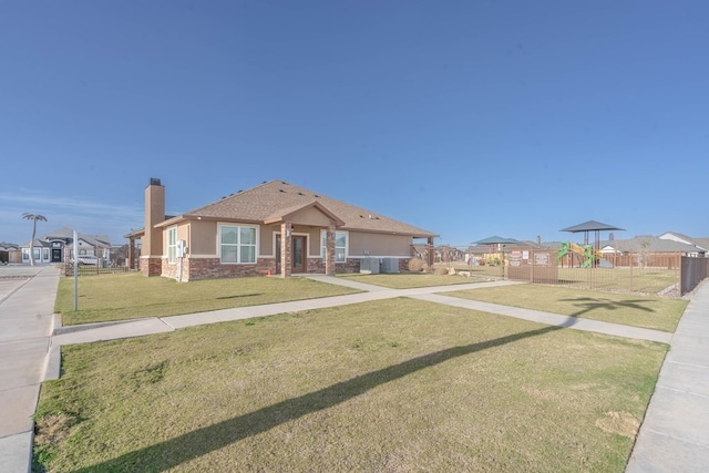 view of front of property featuring a chimney, playground community, a front yard, fence, and a residential view