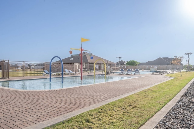 pool featuring fence and a lawn