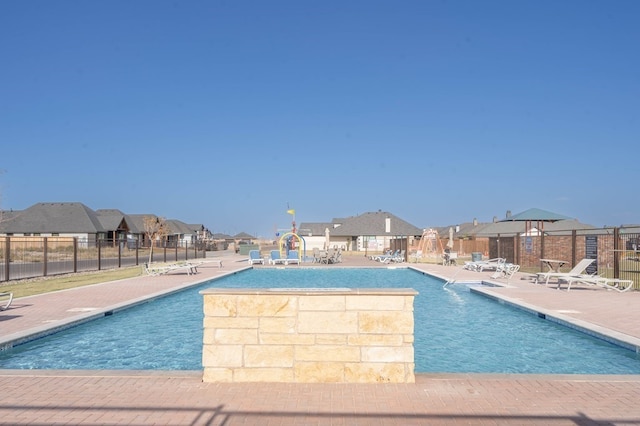 community pool featuring a patio area, a residential view, and fence