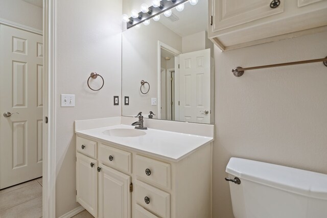 bathroom featuring tile patterned flooring, vanity, and toilet