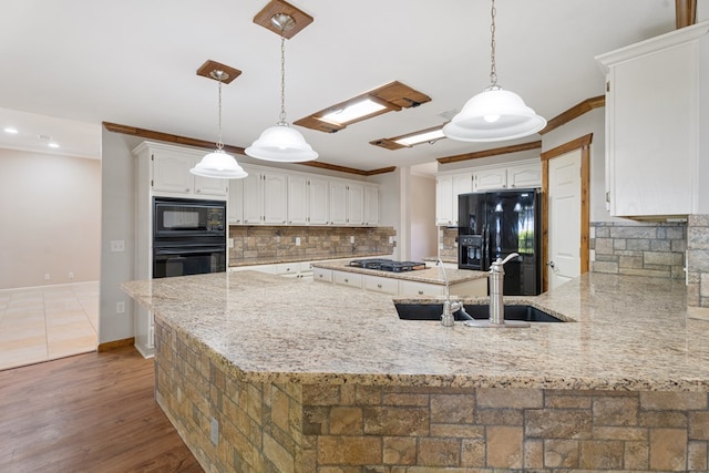 kitchen featuring dark hardwood / wood-style flooring, white cabinetry, hanging light fixtures, and black appliances