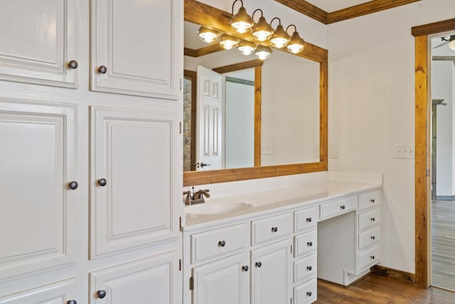 bathroom featuring hardwood / wood-style floors, vanity, and crown molding