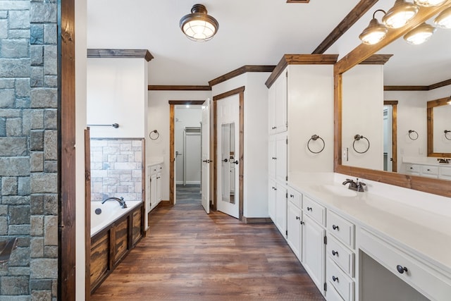 bathroom featuring a tub, hardwood / wood-style floors, vanity, and ornamental molding