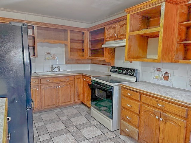 kitchen with black refrigerator, electric range, tasteful backsplash, and sink