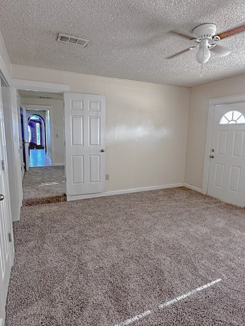 interior space featuring ceiling fan and a textured ceiling