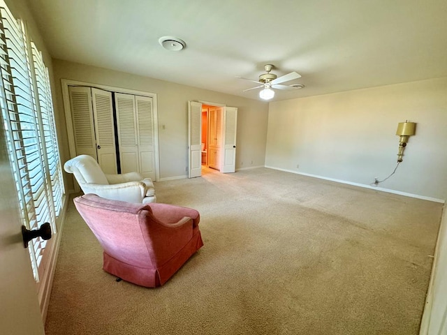 living area with ceiling fan and carpet