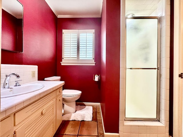 bathroom featuring vanity, tile patterned floors, crown molding, toilet, and walk in shower