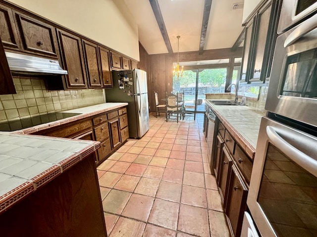 kitchen featuring tile counters, decorative backsplash, sink, and appliances with stainless steel finishes