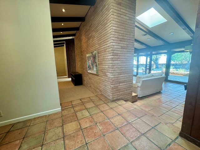 hallway with lofted ceiling with skylight and brick wall