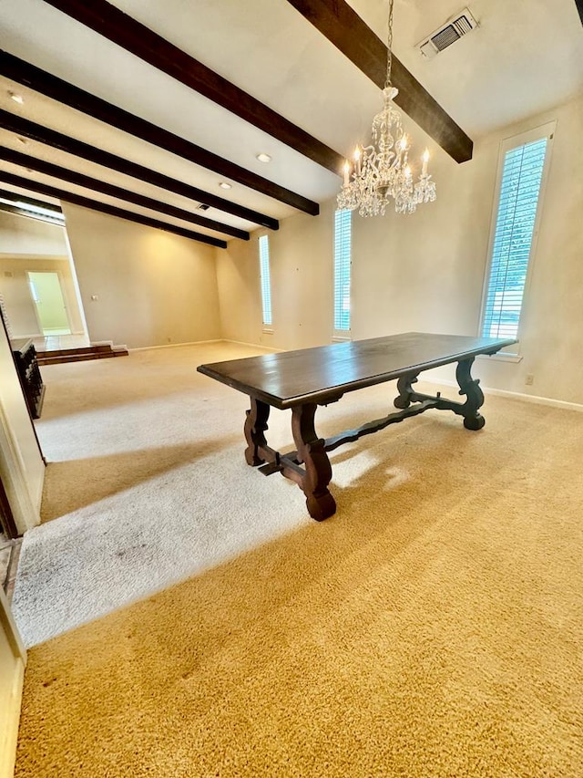 unfurnished dining area with beamed ceiling, carpet floors, and a chandelier