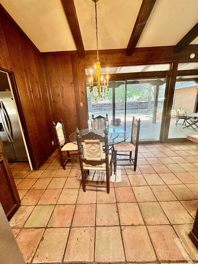 dining area featuring beam ceiling, wood walls, and a chandelier