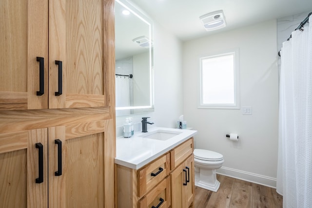 2223 S 2nd Pl, Lamesa, TX 79331 - bathroom with toilet, vanity, baseboards, and wood finished floors