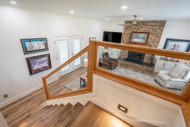 2223 S 2nd Pl, Lamesa, TX 79331 - staircase with ornamental molding, a stone fireplace, ceiling fan, and wood finished floors