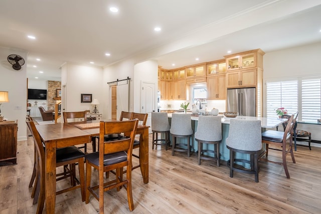 2223 S 2nd Pl, Lamesa, TX 79331 - dining room featuring a barn door, light wood-style flooring, and recessed lighting
