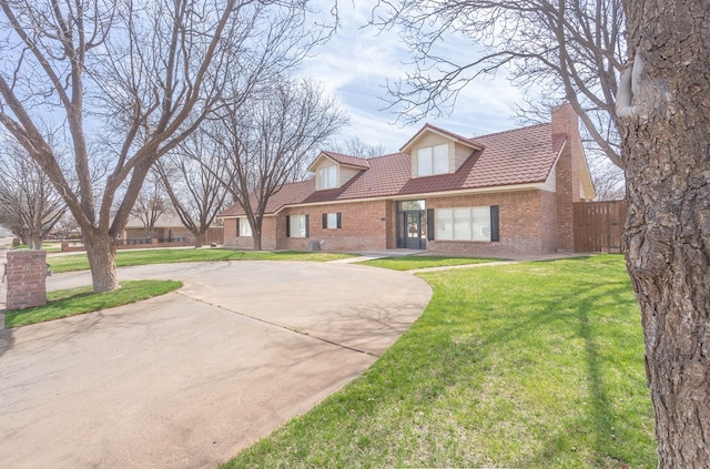 2223 S 2nd Pl, Lamesa, TX 79331 - cape cod-style house with fence, a chimney, brick siding, a front lawn, and curved driveway