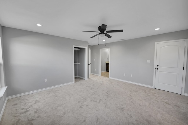 unfurnished bedroom with ceiling fan, ensuite bathroom, and light colored carpet