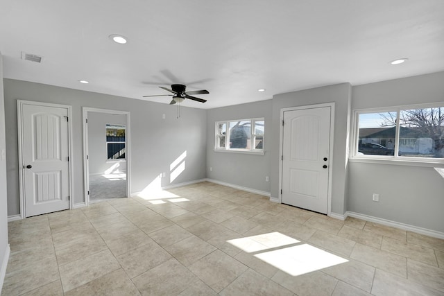 tiled spare room with ceiling fan