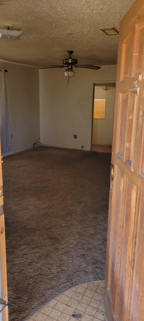 empty room featuring ceiling fan and a textured ceiling