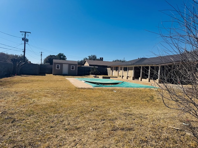 exterior space with a fenced in pool, a fenced backyard, a lawn, and an outdoor structure