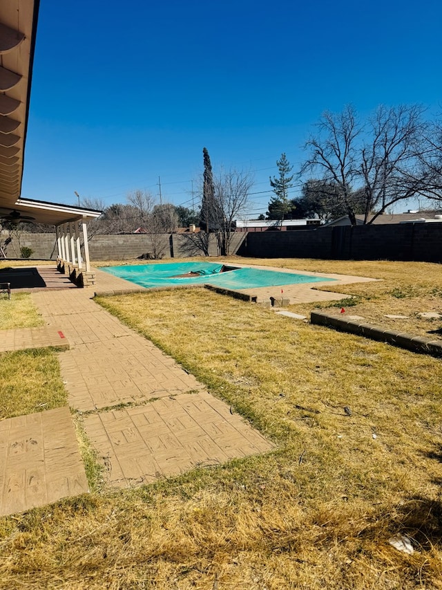 view of pool featuring a yard and fence