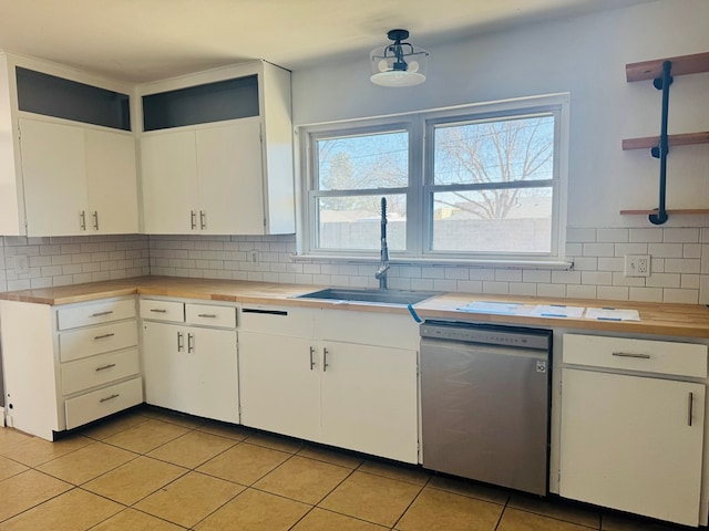 kitchen featuring dishwasher, wooden counters, a sink, and decorative backsplash