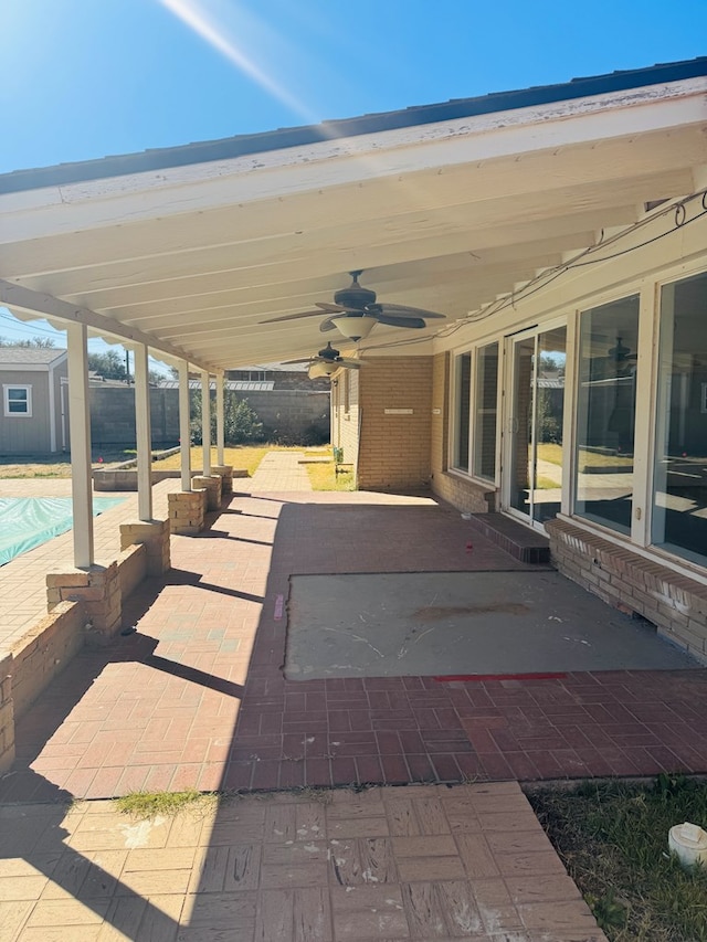 view of patio / terrace featuring fence, a ceiling fan, and an outdoor pool