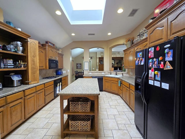 kitchen featuring open shelves, arched walkways, tasteful backsplash, visible vents, and black appliances