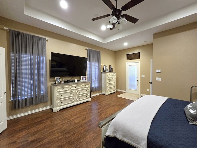 bedroom with recessed lighting, baseboards, a ceiling fan, wood finished floors, and a tray ceiling